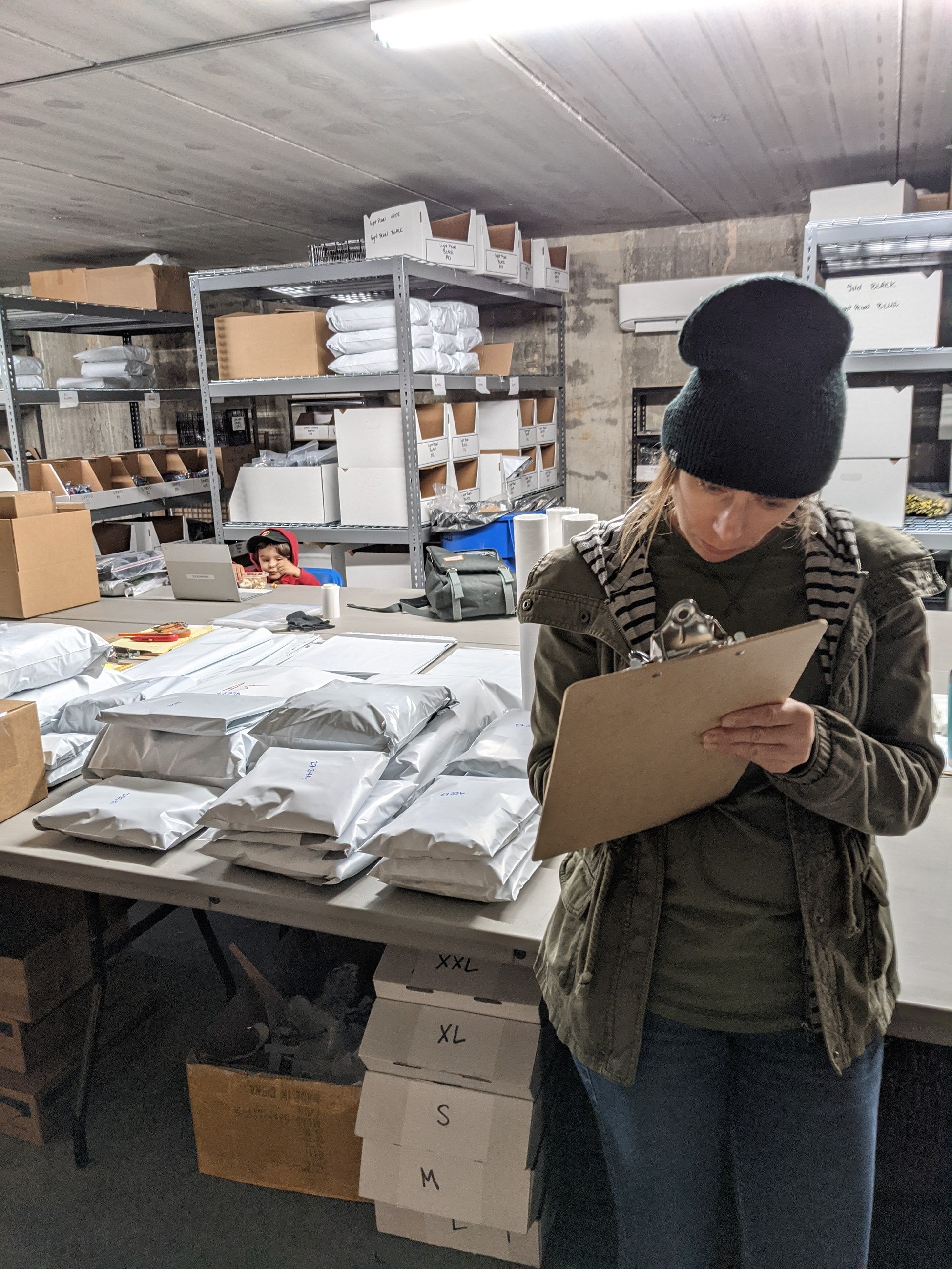 Hillary counting stock with a clipboard in the warehouse, January 2021