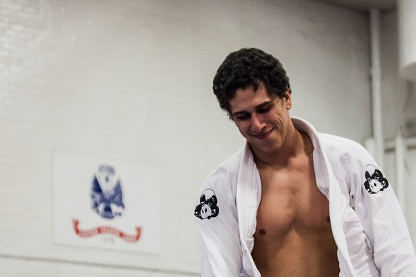 Nelson in an open white gi with panda patches on both shoulders